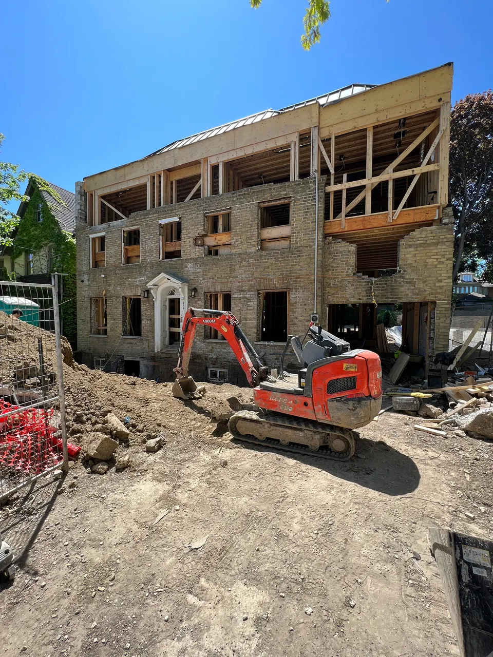 Three-storey framing with an excavator on site